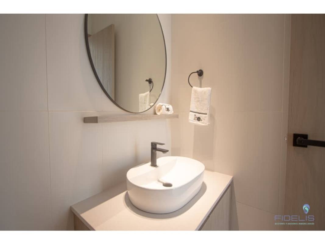Minimalist bathroom with vessel sink and round mirror at Generation Tower Costa del Este