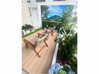 Modern balcony with wooden deck lounge chairs mountain mural and plants at Pinoalto in Boquete Panama