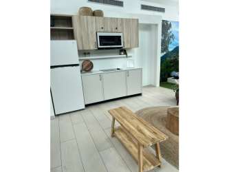 Compact light wood kitchenette with appliances and bench seating at Pinoalto in Boquete Panama