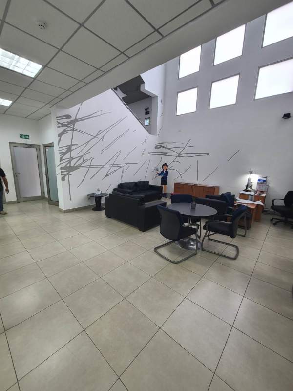 Double height lobby with abstract wall art seating areas large windows in commercial building San Francisco Panama