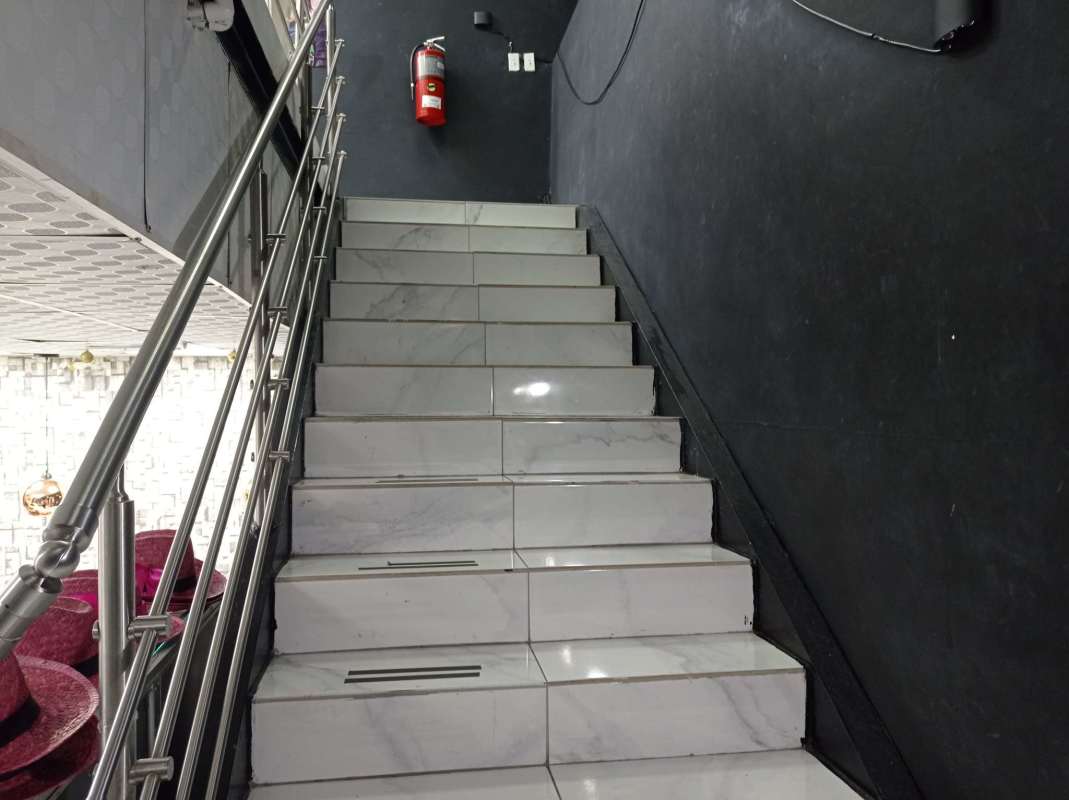 Marble staircase with stainless railings connecting retail floors inside investment property