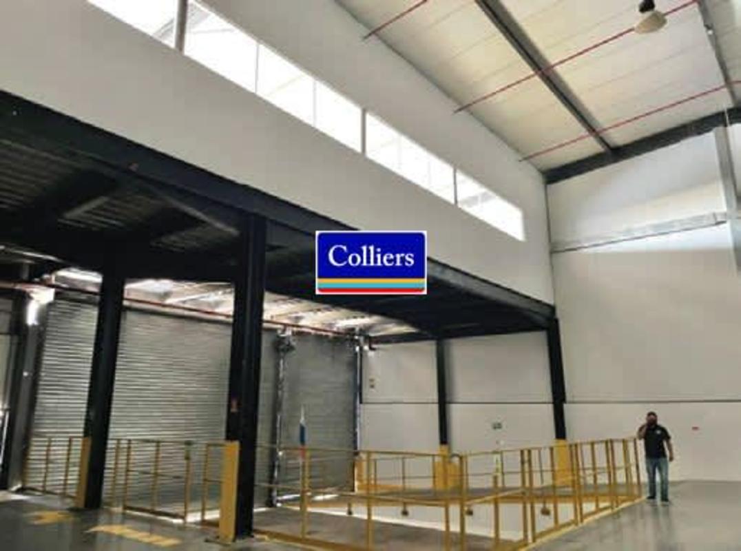 Warehouse space featuring mezzanine with office area and metal support beams in Panama