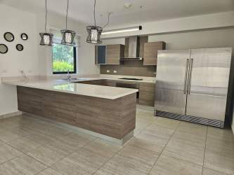 Open plan kitchen dining windows pendant lights stainless appliances Panama Pacifico