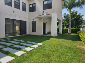 Large modern villa surrounded by palm trees, gardens with large windows in PH Nativa Panama