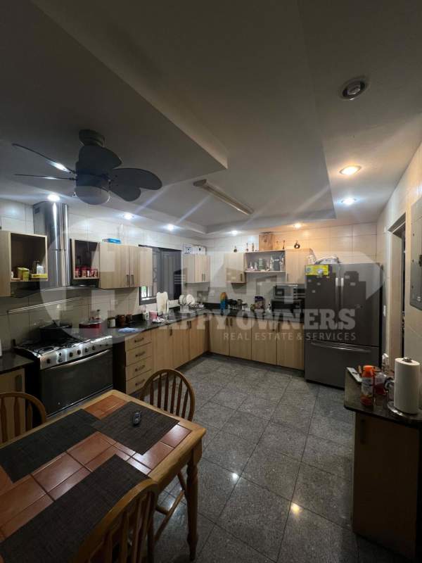 Spacious kitchen with granite counters, light wood cabinetry and dining area in Residencial Versalles Don Bosco