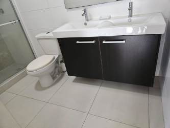 Modern bathroom with double sinks, shower glass enclosure in PH Midrise Woodlands Panama Pacifico