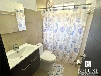 Comfortable bedroom featuring AC unit, wall-mounted TV, window blinds in PH Paraíso Village