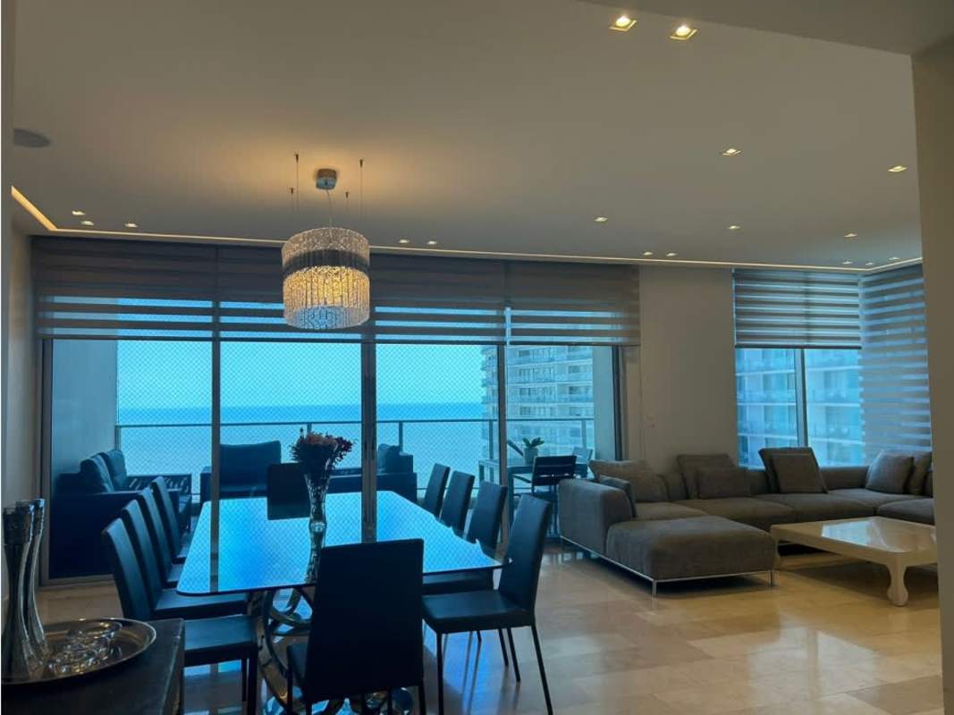Modern open-concept living and dining room with floor-to-ceiling windows, ocean view in PH Pacific Village Punta Pacifica Panama