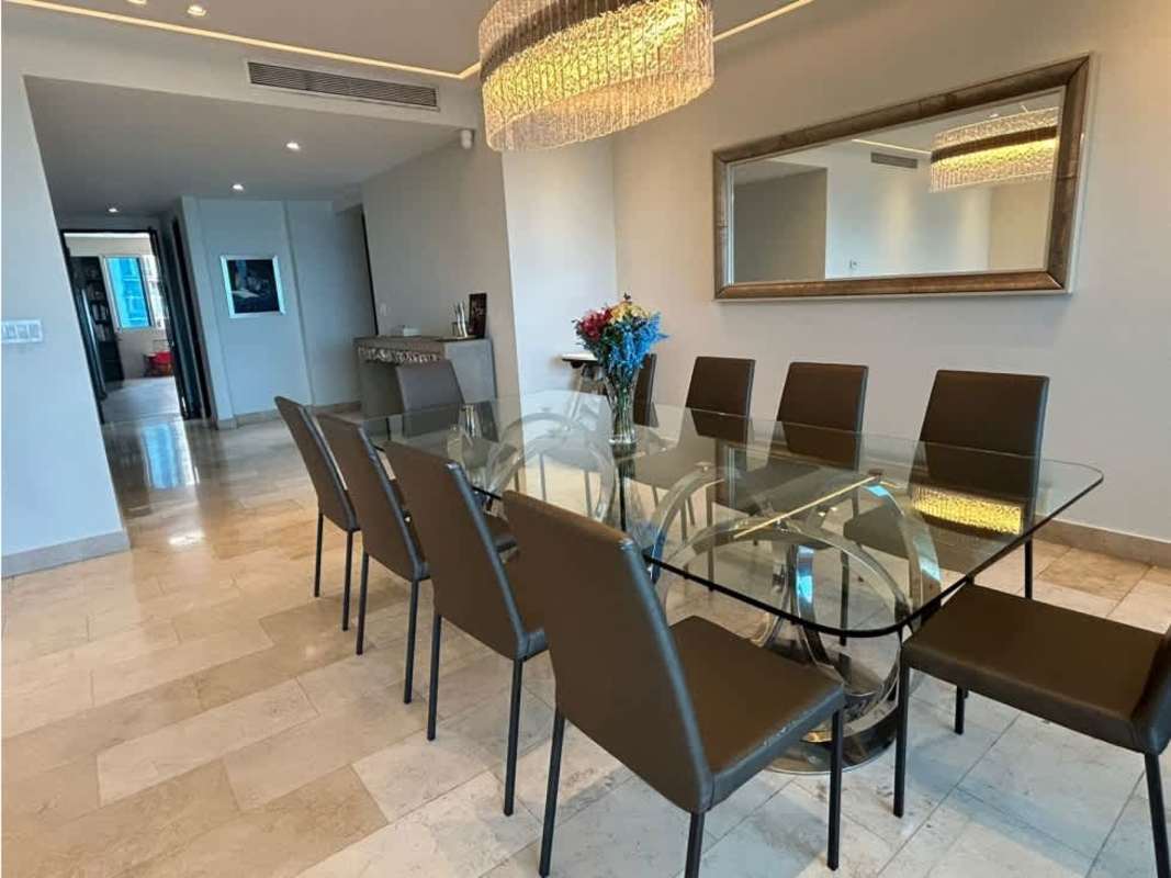Modern dining room with glass table, marble floor, chandelier, ocean view PH Pacific Village Panama