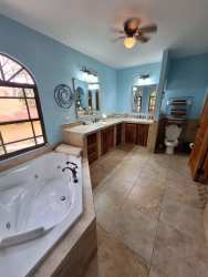 Spacious master bedroom with walk-in closets and jacuzzi style tub at mountain property Panama