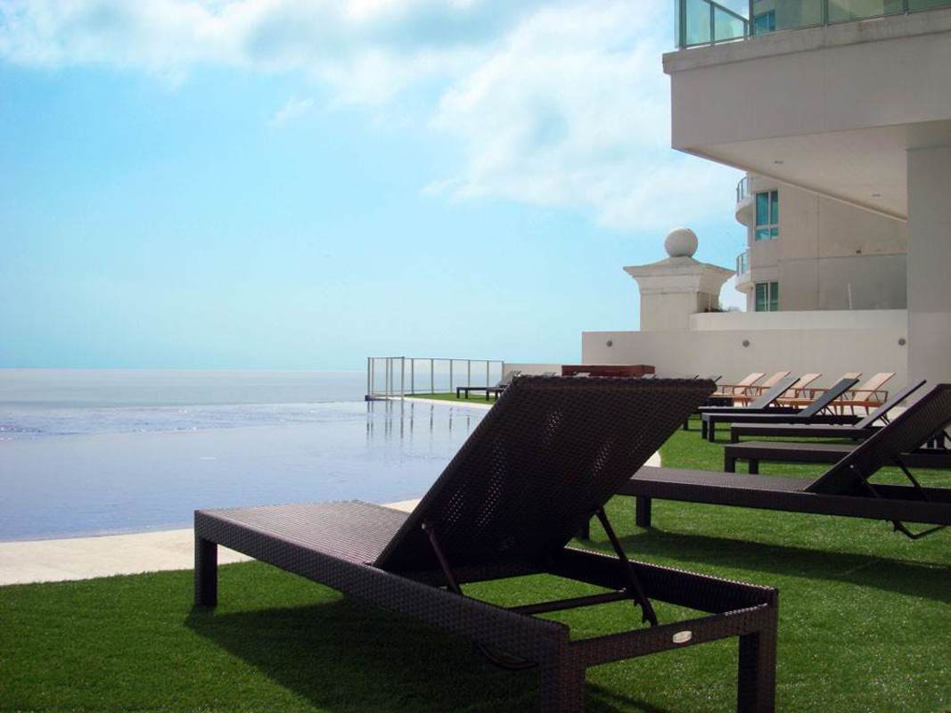 Oceanfront patio, lounge chairs, palm trees and ocean backdrop at Punta Pacifica
