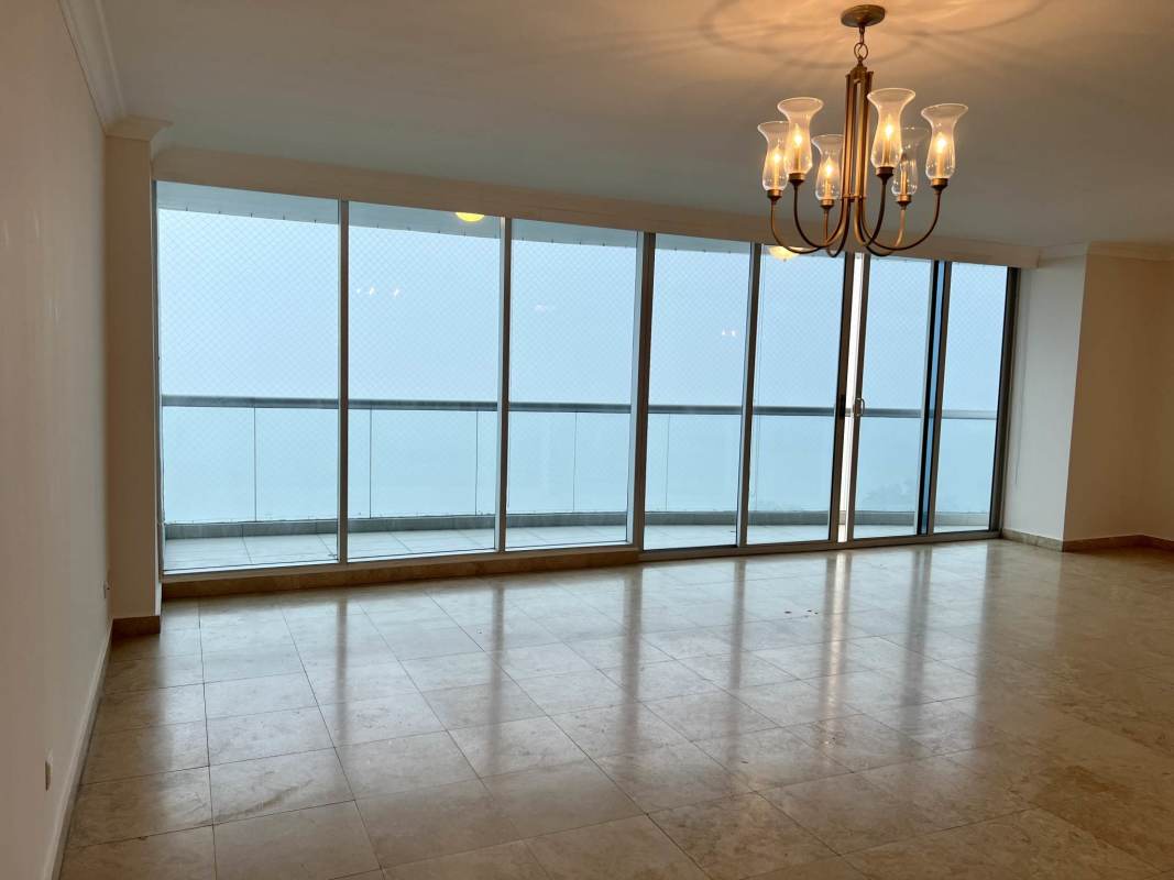 Bright living room with glass doors opening to ocean view balcony at PH Pearl at the Sea Costa del Este Panama