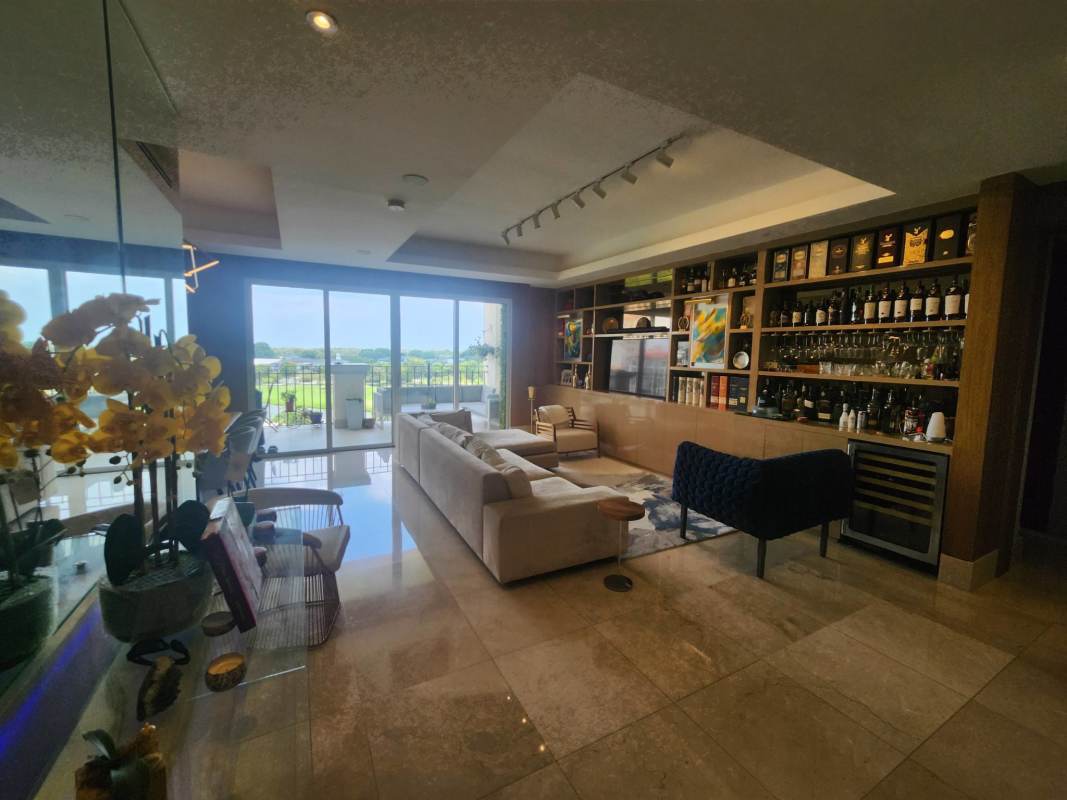 Luxury living room with panoramic glass doors leading to balcony in The Reserve Santa Maria