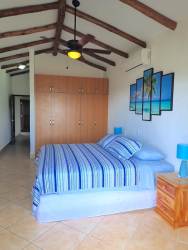 Spacious bedroom with ceiling beams, coastal decor and ocean views in Vista Mar resort Panama