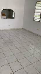 Living room with tiled floor, louvered window and kitchen pass-through window in Penonomé Coclé