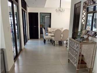 Outdoor swimming pool with sun loungers, palm trees in PH Nativa Panama Pacifico community