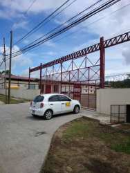 Red rolling gate and fence entrance of warehouse in David Bugaba Panama