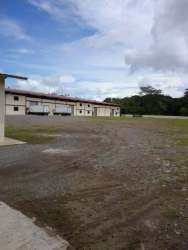 Exterior industrial warehouse building with gravel lot and loading docks in David Chiriquí