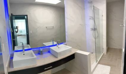 Bathroom with double sinks, large LED mirror, tiled walk-in glass shower Playa Blanca