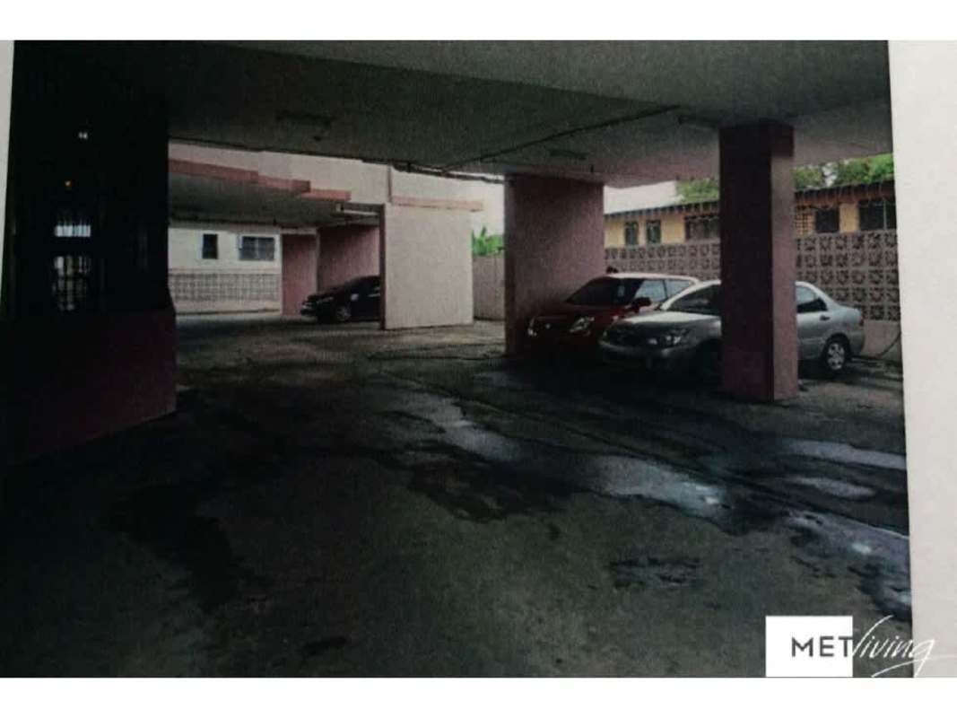 Covered parking garage with cars parked under residential apartment PH Don David Panama