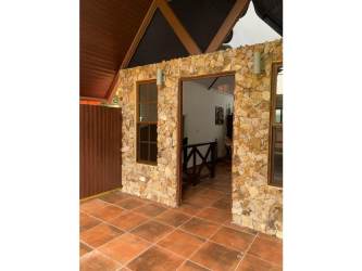 Stone wall entryway with terracotta flooring and wood windows Altos de María Panama villa