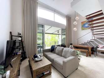 Modern double-height living area with large arch window overlooking the Pacific Ocean in Buenaventura
