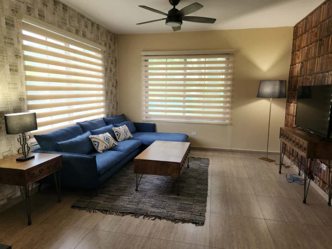 Spacious living room with blue sofa ceiling fan Senderos de Cruces Panama