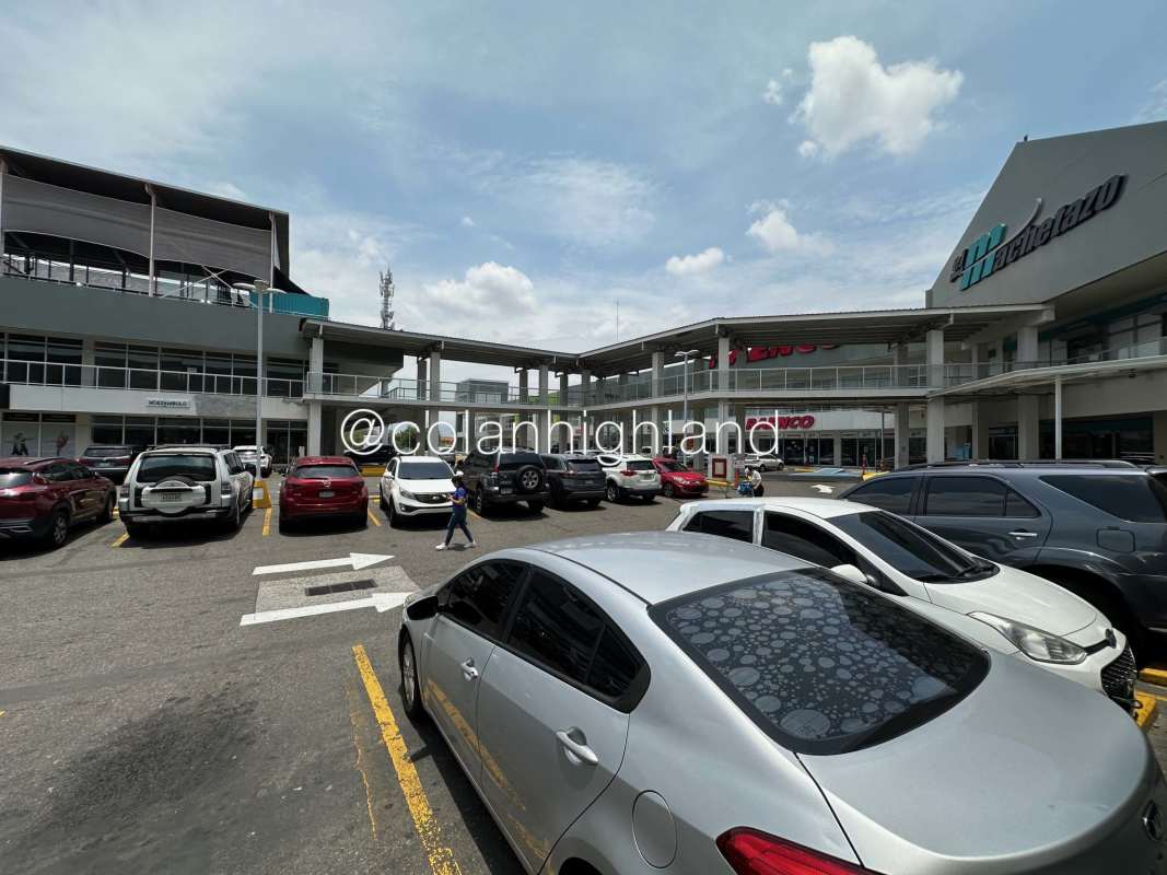 Modern commercial complex with parking area, storefronts and signage in Costa Sur Panama