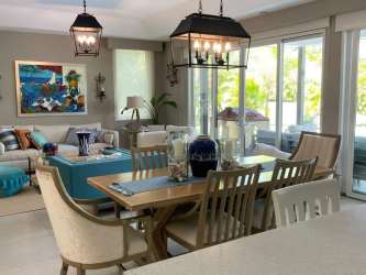 Modern covered patio with BBQ kitchen and dining area overlooking private garden and lagoon in Buenaventura Panama