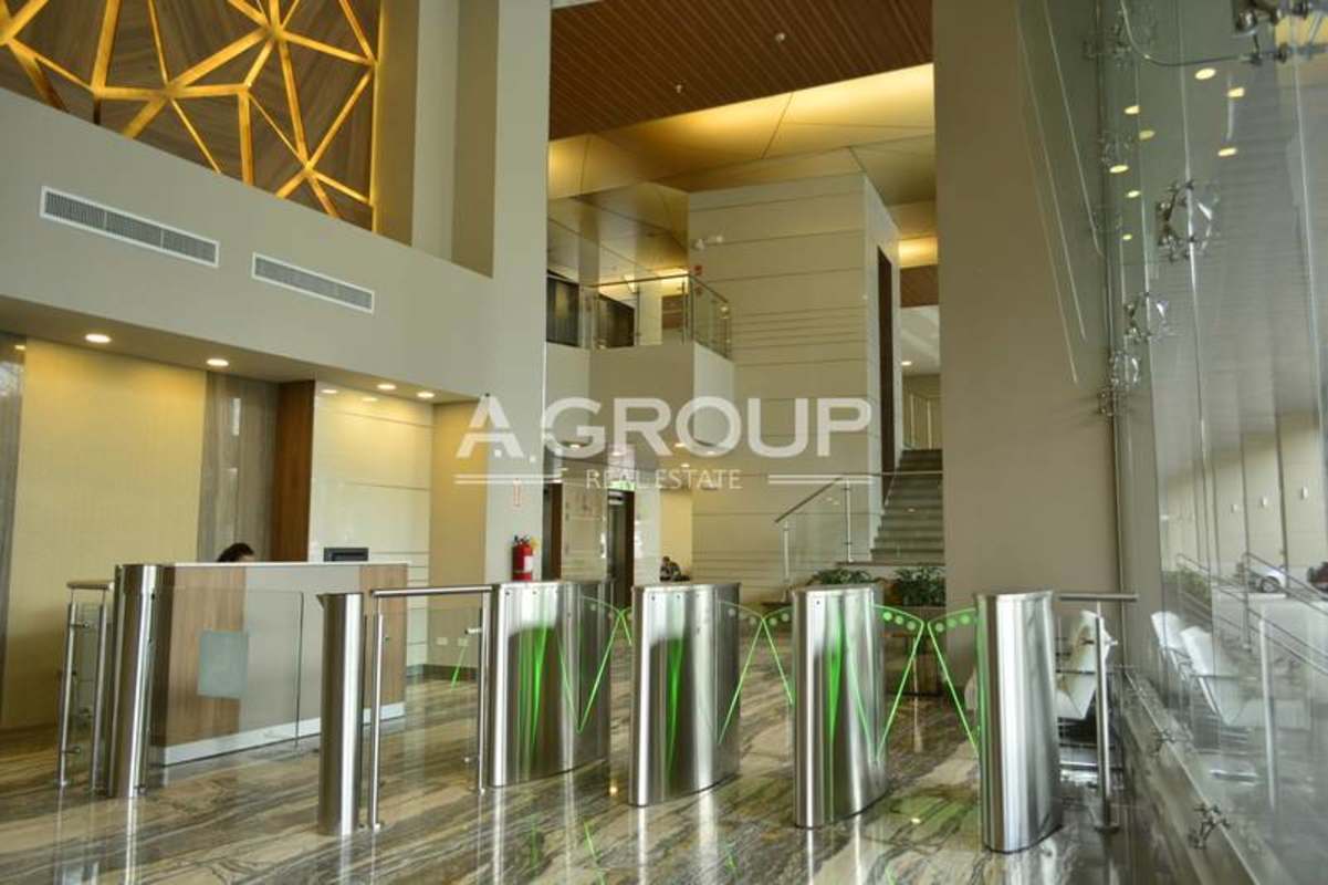 Modern lobby in commercial plaza featuring reception, turnstiles, and geometric wood wall design Panama City.