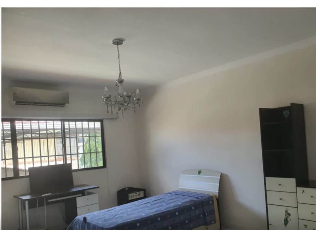 Bright living room with wood furniture and large windows in luxury home La Alameda Panama