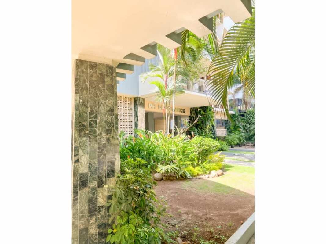 Spacious galley kitchen orange tile backsplash white cabinets PH Diplomático Obarrio Panama