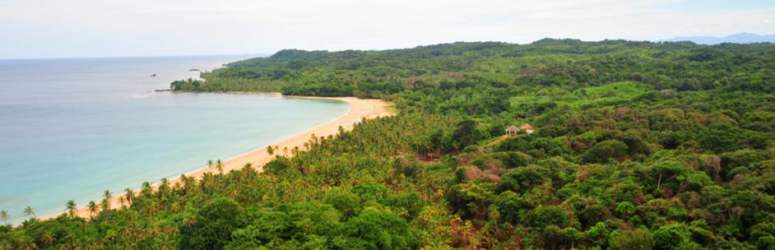 Secluded lush tropical coastal land with sandy beach and Caribbean ocean at San Blas Panama