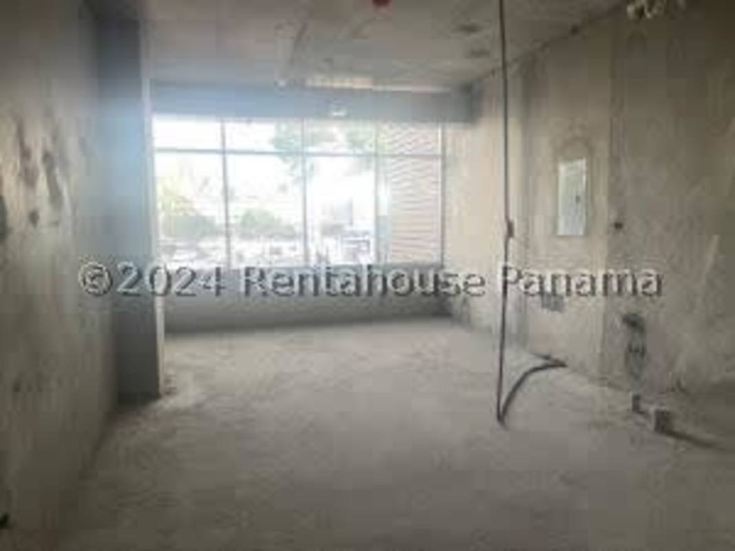 Interior medical clinic office with large window and unfinished concrete walls