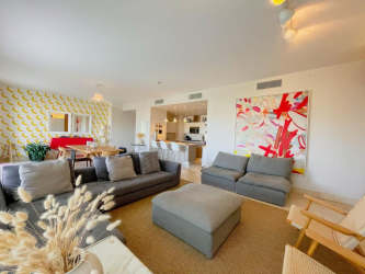 Brightly decorated modern living area with seating and dining in luxury beachfront condo Buenaventura Panama