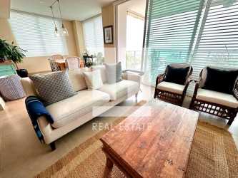 Spacious living room with coastal decor, large windows, balcony access overlooking Pacific Ocean in Rio Mar Panama