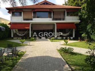 Two-story Mediterranean style house with balconies, tropical landscaping near Pacific Ocean
