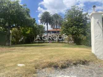 Two-story house with palm trees and lawn near Pacific Ocean in Panama
