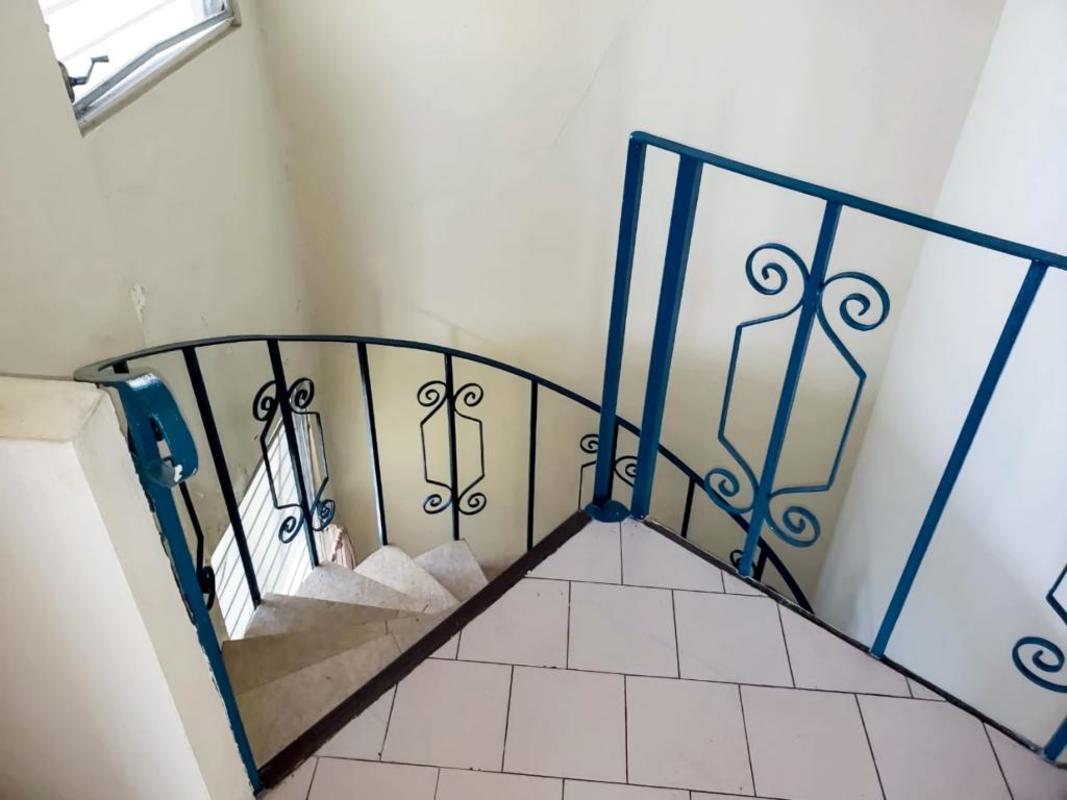 Interior spiral staircase with decorative railing connecting two floors at PH Villa de las Fuentes