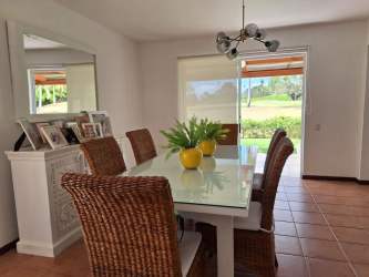 Dining room with wicker furniture, glass table, tropical accents townhouse in Costa Blanca Villas Decameron Panama