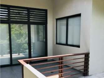 Private balcony with modern sliding glass doors and park view at corner house in PH Nativa Panama Pacifico