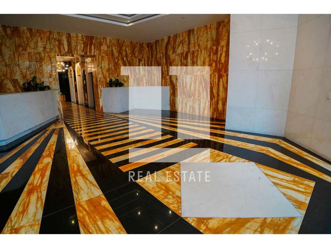 Luxury lobby at Torre SFC with striped marble floors, gold wall accents, chandelier and reception in Obarrio Panama