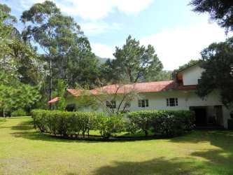 Bedroom with wooden floors, floral bedding and classic design Casa Romero Boquete Panama