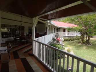 Covered porch overlooking landscaped garden and countryside views at Casa Romero Boquete Panama