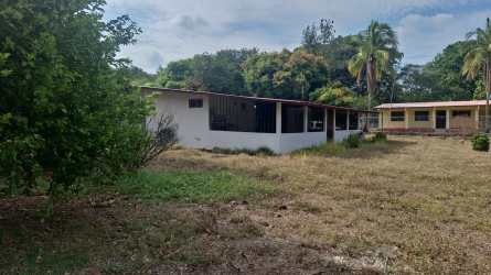 Large rural plot with open field and multiple small houses in Capira Panama
