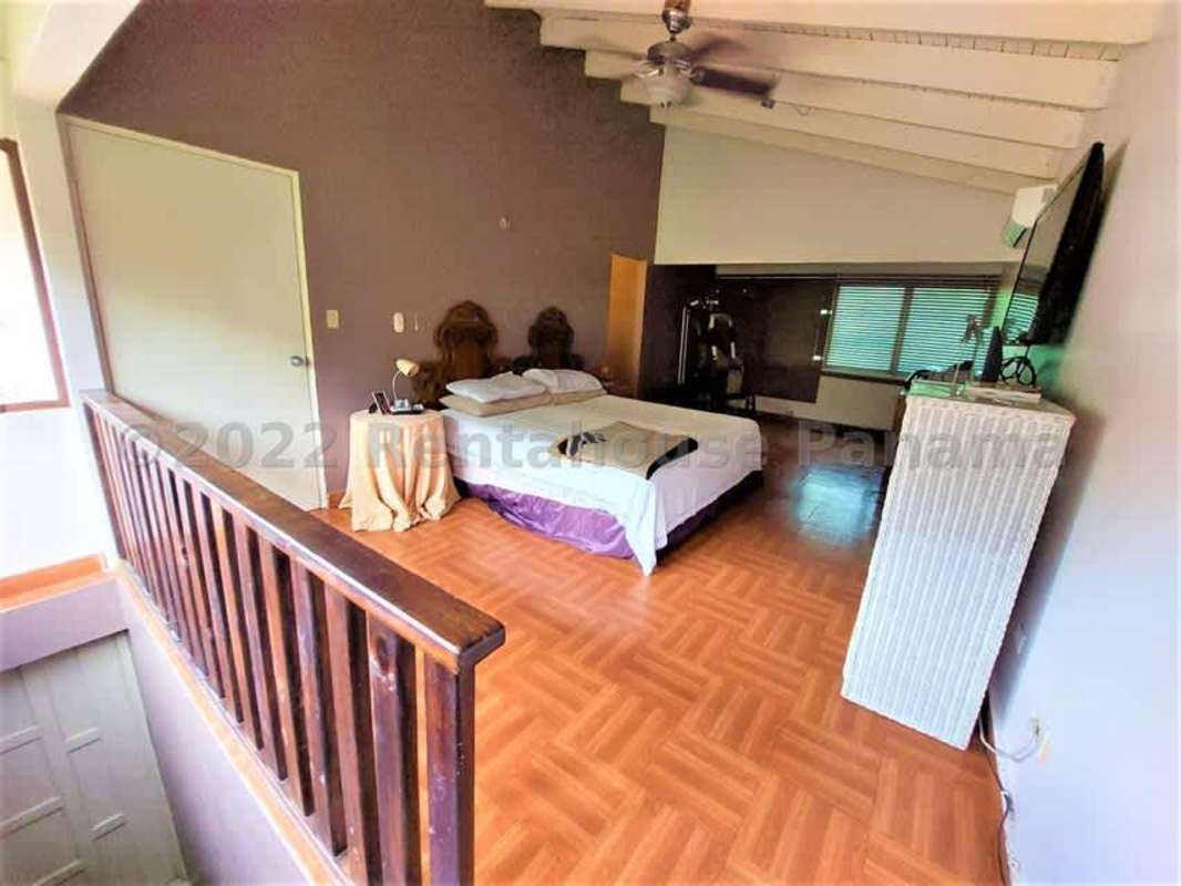 Large bedroom featuring wooden vaulted ceiling, AC, and garden views in Las Cumbres Panama City
