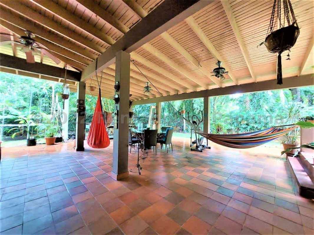 Covered carport with tiled roof, lush landscaping and driveway in Las Cumbres Panama house