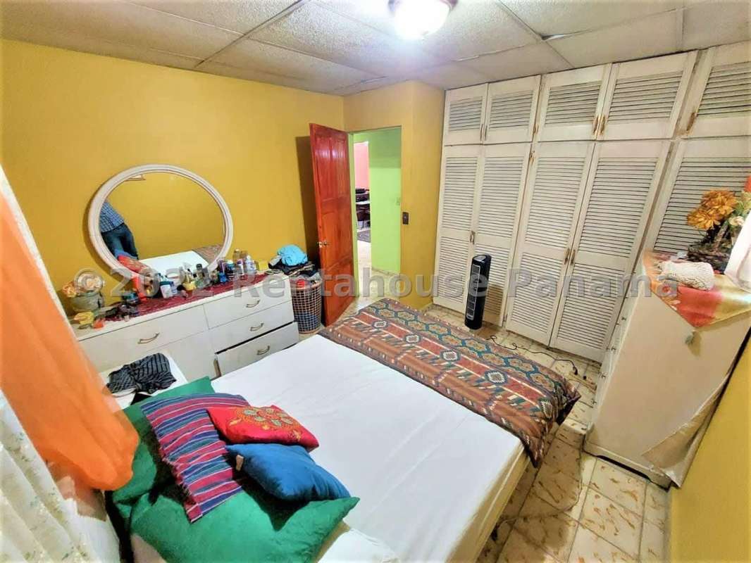 Cozy bedroom with large wooden closet, yellow walls in house for sale La Cabima Panama