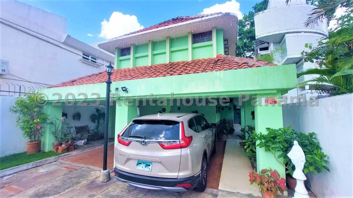 Lush green lawn with tropical plants and security wall fenced backyard La Alameda Betania Panama