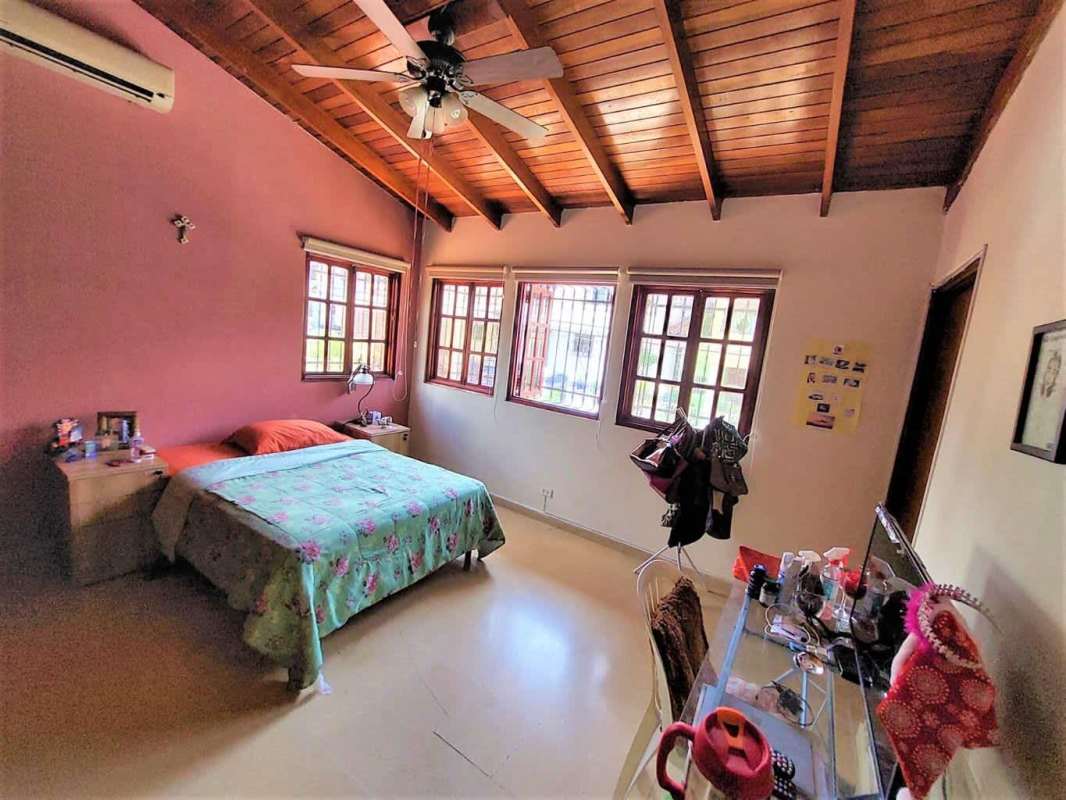 Dining room with large table, staircase, traditional decor, and bright windows in Panama City house